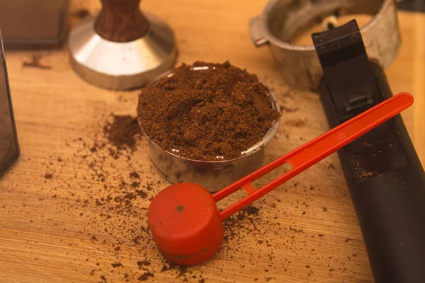 Tamper café con café en cesta de filtro y soporte de filtro en una tabla de madera — Foto de Stock