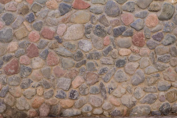 Antigua pared de piedra de piedras redondas y cemento gris — Foto de Stock