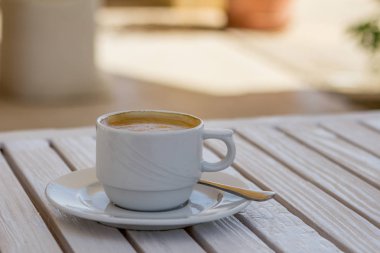 güneşli bir yaz bir beyaz tahta masada beyaz kapuçino Kupası