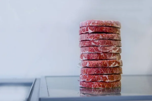Ένας σωρός από ωμό κρέας κοτολέτες για ένα μπέργκερ σε έναν πίνακα — Φωτογραφία Αρχείου