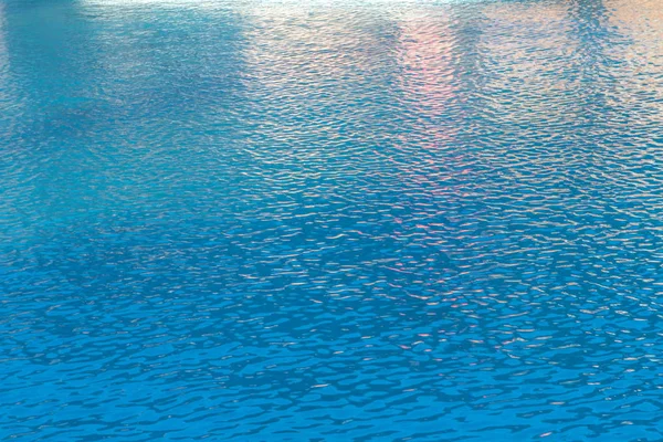 Olas pequeñas y ondas en el agua azul de la piscina — Foto de Stock