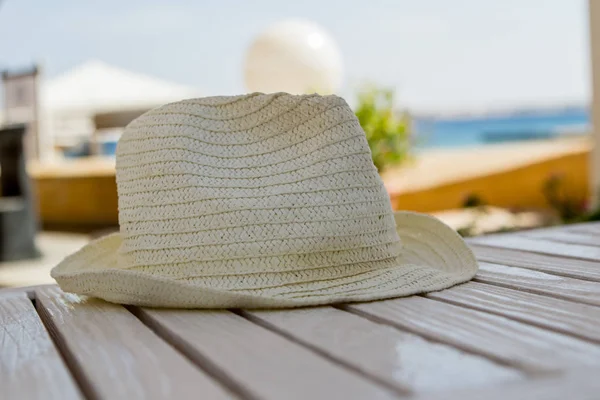 Beyaz ahşap bir masa üzerinde hasır şapka