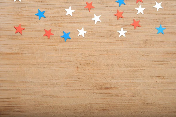 Confetti sterren op houten achtergrond. 4 juli, Onafhankelijkheidsdag, card, uitnodiging in usa vlag kleuren. Uitzicht vanaf de Top, lege ruimte. — Stockfoto