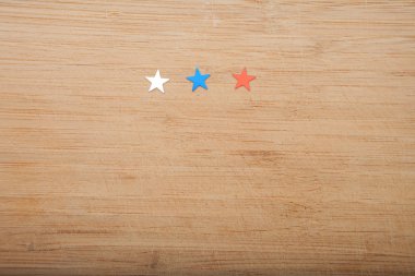 Konfeti yıldız ahşap arka plan üzerinde. Temmuz 4, bağımsızlık günü, kart, ABD bayrağı renklerde davet. Üstten görüntülemek, alan boş.