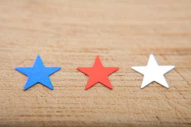 Konfeti yıldız ahşap arka plan üzerinde. Temmuz 4, bağımsızlık günü, kart, ABD bayrağı renklerde davet. Üstten görüntülemek, alan boş.