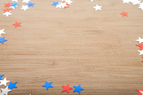 Konfeti yıldız ahşap arka plan üzerinde. Temmuz 4, bağımsızlık günü, kart, ABD bayrağı renklerde davet. Üstten görüntülemek, alan boş.