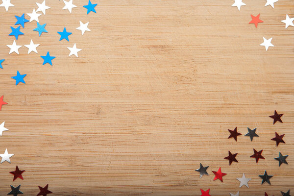 Confetti stars on wooden background. 4th July, Independence day, card, invitation in usa flag colors. View from Top , empty space.