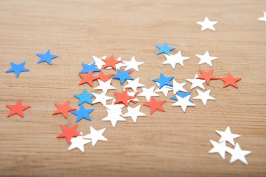 Konfeti yıldız ahşap arka plan üzerinde. Temmuz 4, bağımsızlık günü, kart, ABD bayrağı renklerde davet. Üstten görüntülemek, alan boş.