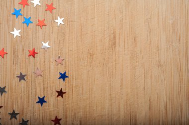 Konfeti yıldız ahşap arka plan üzerinde. Temmuz 4, bağımsızlık günü, kart, ABD bayrağı renklerde davet. Üstten görüntülemek, alan boş.