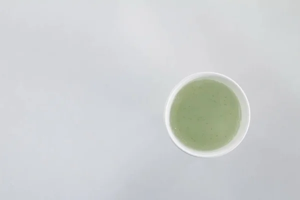Белый кофе чашку изолированы на белом с зеленым соком вид сверху . — стоковое фото