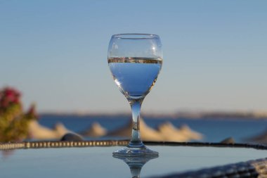 denizde masada bir saman ile bir bardak taze soğuk su. Yaz tatil tatil kavramı.