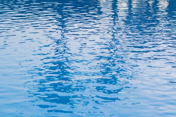 Agua azul con olas en la piscina por la mañana . — Foto de Stock