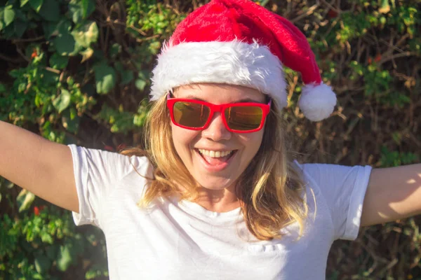 Portrait d'une jolie jeune femme en chapeau et lunettes de soleil du Père Noël. tonique . — Photo