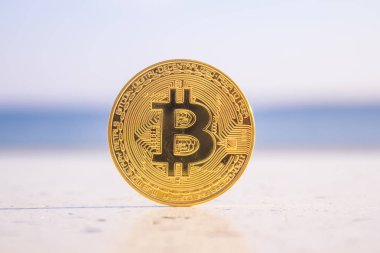 Altın bitcoin sikke üzerinde plaj arka plan olarak.