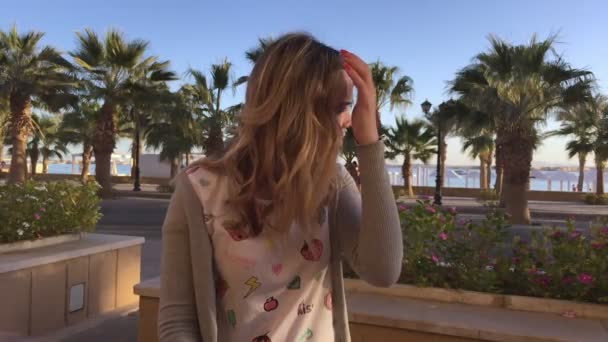 Portrait of young and beautiful woman at beach cafe. palms and sea — Stock Video