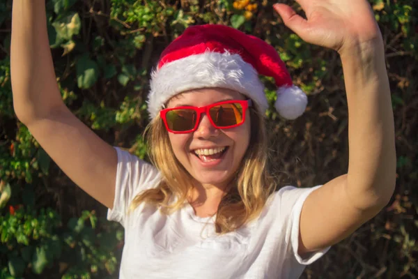 Portrait d'une jolie jeune femme en chapeau et lunettes de soleil du Père Noël. tonique . — Photo