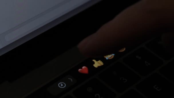 Чоловік набирає на ноутбук емодзі серце — стокове відео