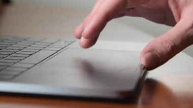 Adam dizüstü bilgisayarı kullanıyor ve touchpad üzerinde çalışmak