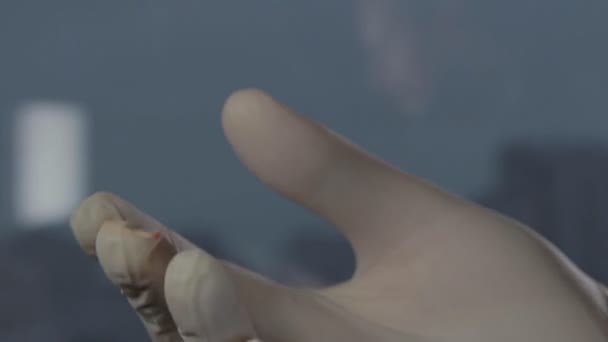 男性戴手套的手摩擦他的手指在受感染的区域后, 检查 — 图库视频影像