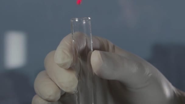 남성 장갑 낀된 손을 잡고 테스트 튜브 또는 명확한 액체 유리. — 비디오