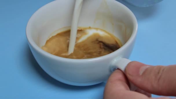 du lait est versé dans une tasse à café pour faire un cappuccino 
