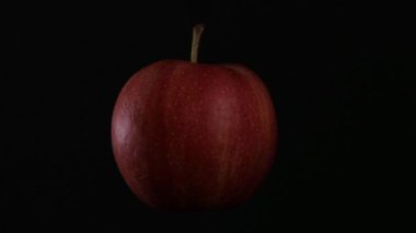 kırmızı elma izole bir siyah arka plan üzerinde iplik
