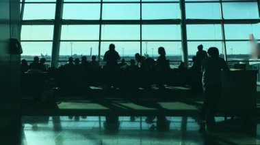 İnsanlar güneşli bir günde terminal havaalanında uçuş için bekliyor