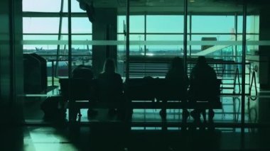 İnsanlar güneşli bir günde terminal havaalanında uçuş için bekliyor