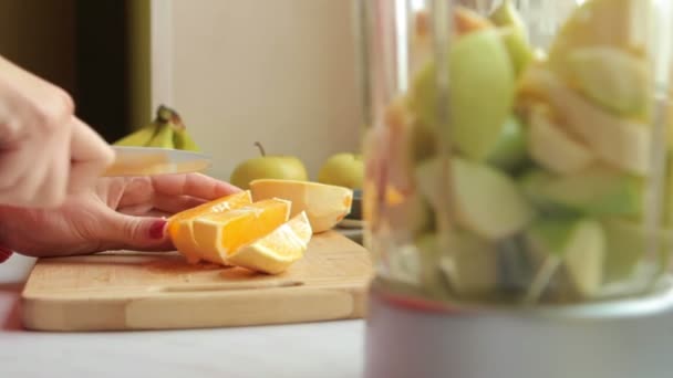 Kvinna skar Orange och lägga till det i mixer — Stockvideo