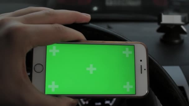 Hand of man holding mobile smart phone with chroma key green screen in car — Stock Video