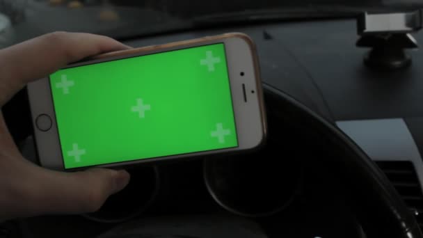 Χέρι του άνδρα να κρατάει κινητό έξυπνο τηλέφωνο με chroma κλειδί πράσινη οθόνη στο αυτοκίνητο — Αρχείο Βίντεο
