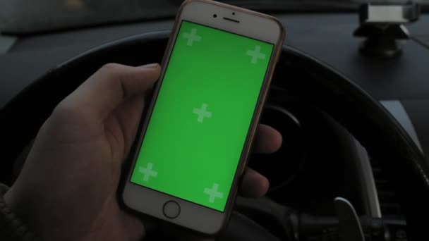 Mano del hombre que sostiene el teléfono inteligente móvil con la pantalla verde de la llave del croma en coche — Vídeos de Stock