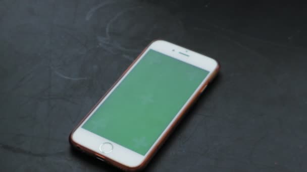 Teléfono inteligente, en la mesa rústica negra. pantalla verde — Vídeo de stock