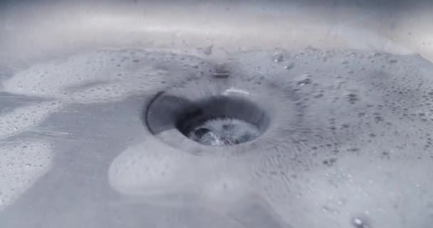 Wasser mit Schaumstoff fließt langsam zu einer Metallspüle — Stockvideo