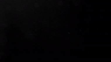 Siyah arkaplanda bokeh olan parçacıklar