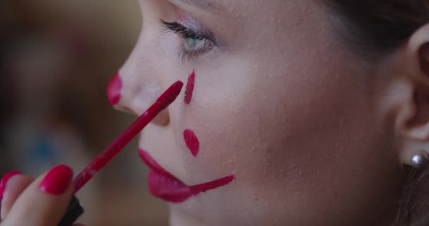 Krásná mladá žena použití make-up klaun na tváři doma — Stock video