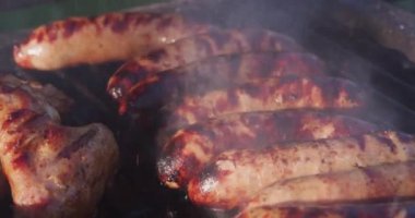 Kömür ızgarasında ateşte ızgara sosis.