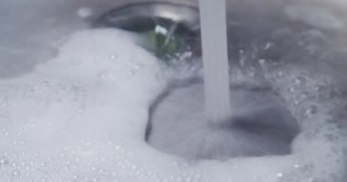 Mutfak lavabosu su ve köpük tıkanıklığıyla dolu.