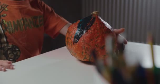 Un garçon décorant et peignant la citrouille pour Halloween — Video