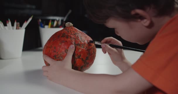 One boy decorating and painting pumpkin for halloween — Stock Video