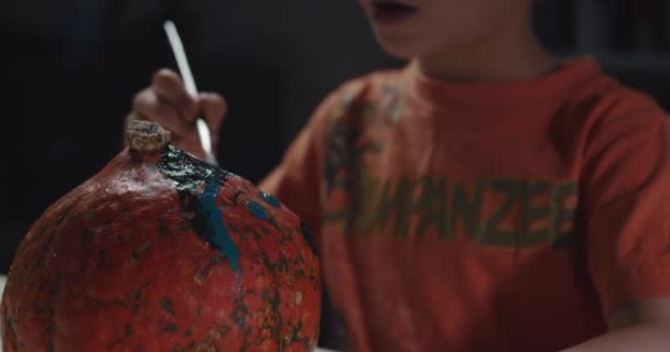 Un niño decorando y pintando calabaza para Halloween — Vídeos de Stock