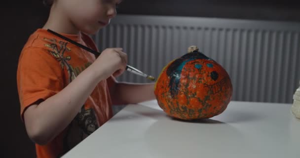 Un niño decorando y pintando calabaza para Halloween — Vídeo de stock