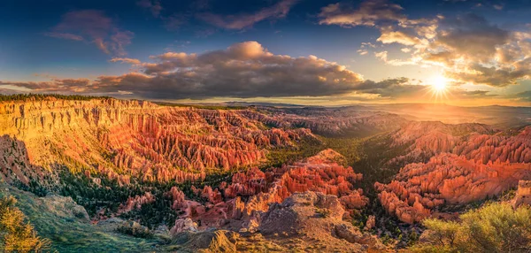 Bryce Canyon za úsvitu, zářící slunce a pestré mraky — Stock fotografie