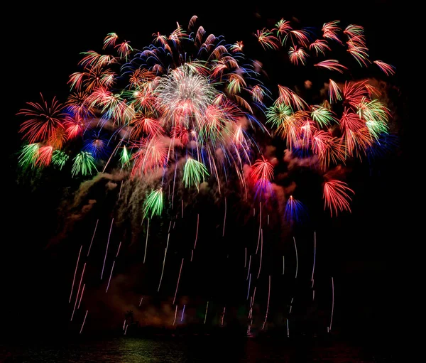 Molti fuochi d'artificio colorati con piste che cadono nella notte scura nera — Foto Stock