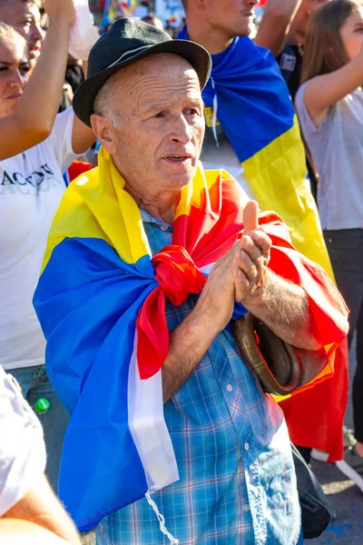 Um homem velho protestando com outros milhares de manifestantes tem ra — Fotografia de Stock