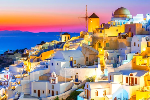 Oia ciudad, isla de Santorini, Grecia al atardecer. Casas blancas tradicionales y famosas e iglesias con cúpulas azules sobre la Caldera, el mar Egeo . —  Fotos de Stock