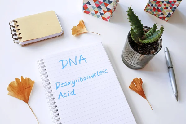 DNA Deoxyribonucleic Acid written in notebook on white table