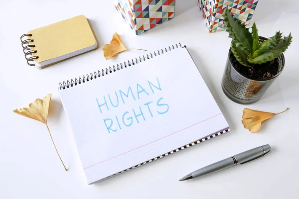 白いテーブルにノートに書かれた人権 — ストック写真