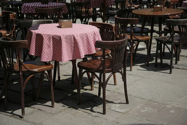 Chaises et tables en bois vides dans un café de rue — Photo