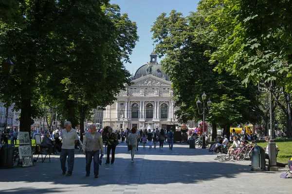 Lviv, Ukrayna - 1 Haziran 2019: Arka planda Lviv Opera ve Bale Tiyatrosu ile Freedom Avenue'de dolaşan turistler. En popüler Lviv dönüm noktası — Stok fotoğraf